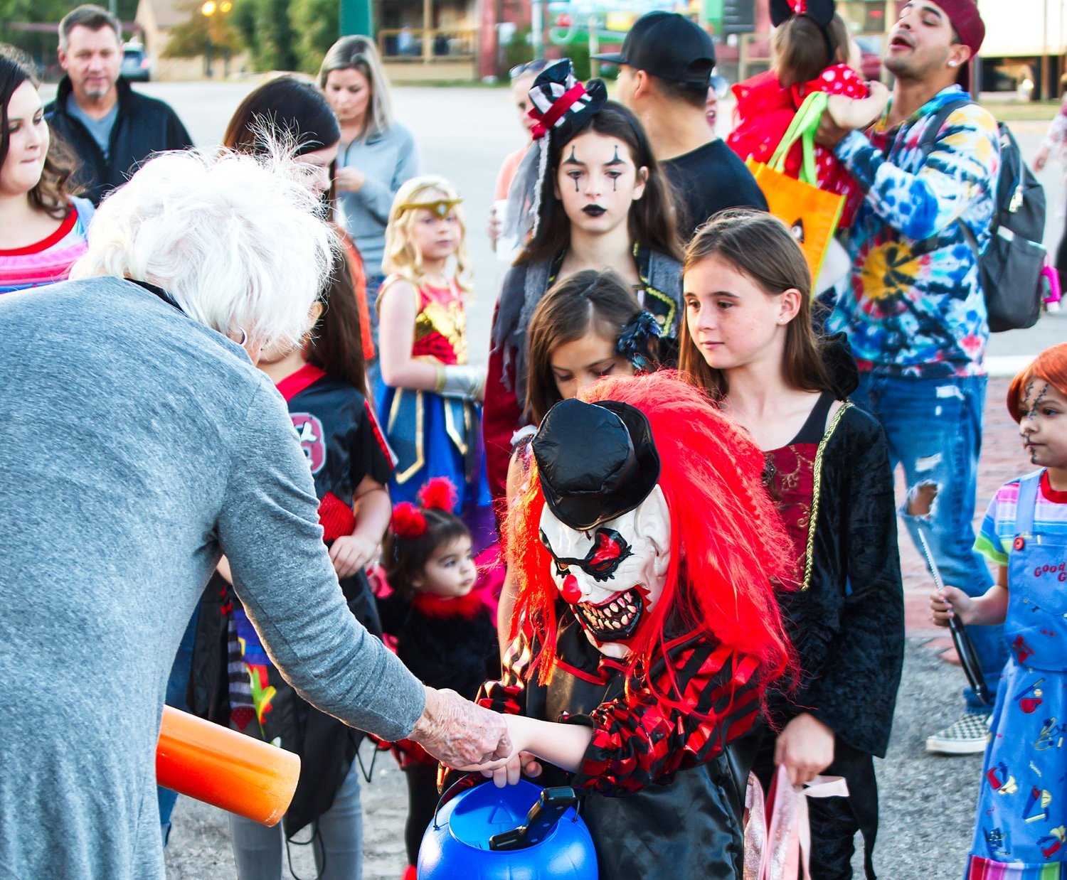 A crowd gathers for candy near the gazebo in downtown Mineola on the evening of Halloween.